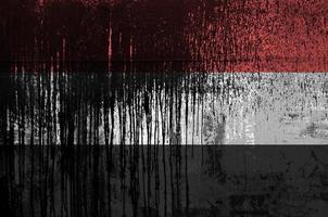 Yemen flag depicted in paint colors on old and dirty oil barrel wall closeup. Textured banner on rough background photo
