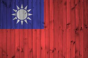 Taiwan flag depicted in bright paint colors on old wooden wall. Textured banner on rough background photo