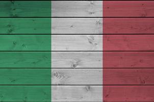 Italy flag depicted in bright paint colors on old wooden wall. Textured banner on rough background photo