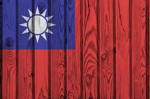 Taiwan flag depicted in bright paint colors on old wooden wall. Textured banner on rough background photo