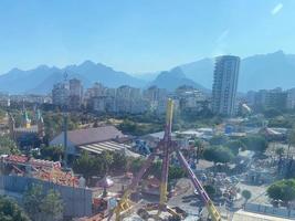 vista superior aérea del parque de atracciones con atracciones y árboles en la mañana de verano foto