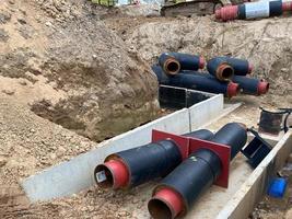 Large industrial modern new large diameter polyethylene plastic water pipes lie in a pit underground at a construction site during a water pipe repair photo