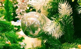 White old Christmas toy and red glass balls on green spruce branches photo