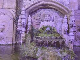 in the oceanarium there is a large stone waterfall with flowing water. Buddha temple made of stone, a zone of peace and unity with nature photo