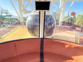 ride on a ferris wheel. inside the booth - seating and a table. cabin made of metal, round shape for a sightseeing tour on a wheel. leisure photo