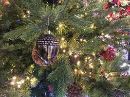 Green branches of a fluffy Christmas festive New Year tree with toys and bright glowing light bulbs and garlands, background photo