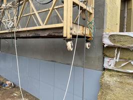 External finishing with mineral wool insulation in the cradle of the assembly of a new facade of a high building of a building made using monolithic-frame construction technology photo