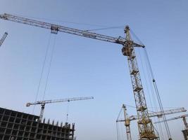 construction crane on a background of blue sky. crane for moving heavy concrete blocks for the construction of houses and high-rise buildings photo