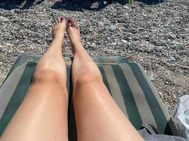 Low Section Of Woman Relaxing At Beach photo