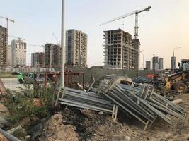 large wooden pallets lie against the backdrop of multi-storey buildings. construction of a new microdistrict in the city center. new house photo