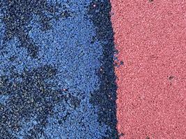 Blue and red texture of the soft rubber surface of the safe cover of the sports playground for workout made of pressed fine rubber photo