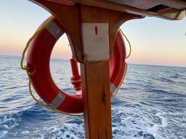 Anillo salvavidas en bote grande. Equipo de barco obligatorio. Dispositivo de flotación personal. Evitar ahogamiento. Salvavidas naranja en la cubierta de un crucero. Viajar a una isla. foto