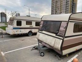 Old white rusty caravan trailers, mobile homes are parked photo