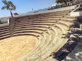 antique amphitheater. stadium for battles and performances in the ancient world. steps and stairs made of concrete. spectator seats with symbols drawn in chalk photo