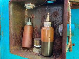 Old small jars are dirty with machine-made brown industrial oil. Oiler for lubrication of parts and internal combustion engine photo