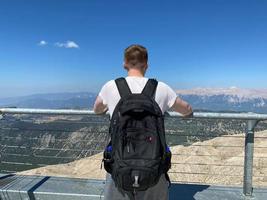 Tourist with a backpack on the background of mountains photo