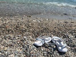 flip flops on the pabble beach. Summertime sea holiday concept. Top view. Copy space photo