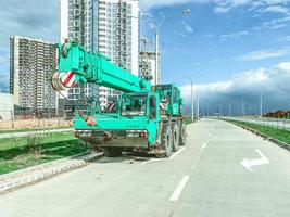 The boom-type crane moves without a load, without requiring special tracks. truck crane at the construction site of a new microdistrict photo