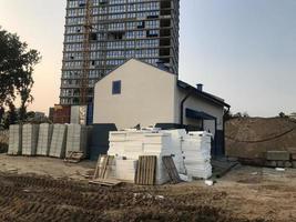 construction of a new microdistrict in the city center. tall concrete block houses. next to the house is a place for electrical communications. infrastructure creation photo