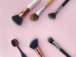 brushes on a pink matte background. brushes for blush, powder, foundation and contouring. a tool for the work of a makeup artist. unusual brushes for treating the skin of the face, clear skin photo