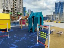 Children's new modern sports playground with various activities, games, swings, slides, carousels and sandpits with a rope town in the open-air courtyard photo