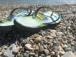 blue sandals and seastars on white pebbles by the shore photo