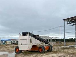 camión pequeño con grúa de carga para descargar materiales de construcción en un sitio de construcción. concepto de obras viales foto