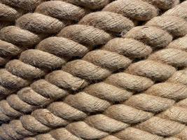 Diagonal strands of a new thick sisal and hemp rope with twisted braided fibers in a full frame close up background texture photo