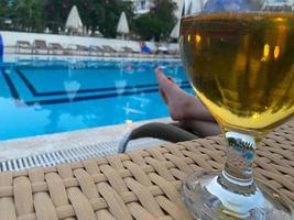 A glass of cold beer in front of the pool photo