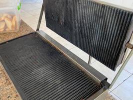 Large black iron grill for frying meat food in the kitchen in the cafeteria in the cafeteria fast food restaurant photo