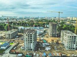construction of a new residential complex in the city center. view of the construction site from above. construction of high-rise buildings from blocks using a metal crane photo