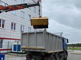 A large, powerful garbage truck unloads garbage with a manipulator for subsequent recycling of resources photo