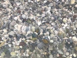piedras de mar bajo el agua. agua de mar y guijarros foto