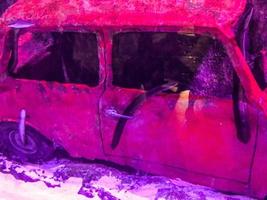 bright, red car sank at the bottom of the sea. car without windows and windshield. nearby, an eel climbed inside the car and sits on the handles photo
