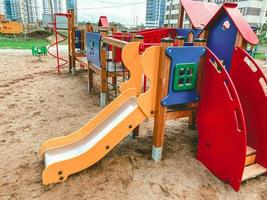 atracciones para niños en el parque infantil. un tobogán con carrera de obstáculos y una casita amarilla de materiales ecológicos para el contacto con los niños. juegos al aire libre foto