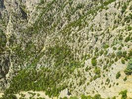 high mountains in a hot, tropical country. texture with sand and stones. mountain with green bushes and herbs. 3d background, natural texture photo