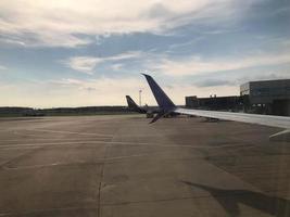 view on the wing from the window of a plane above runway photo