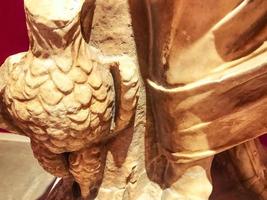 three-dimensional texture, plaster sculpture, ancient art. on the texture of scuffs, chips, cracks. sculpture with a bull in hand photo