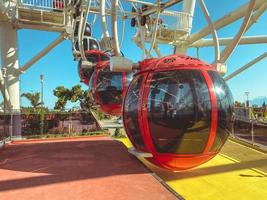 on the Ferris wheel there are large cabins for skiing tourists of red color with black, tinted windows. a place for boarding tourists in a cabin photo