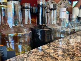 necks of bottles with alcohol on the bar counter in the duty free hotel with free drinks photo