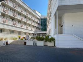 exterior diurno que establece una toma de apartamento genérico, hotel o edificio de condominios en una ubicación de destino de vacaciones tropicales durante el clima de verano. palmeras y poste de luz en primer plano foto