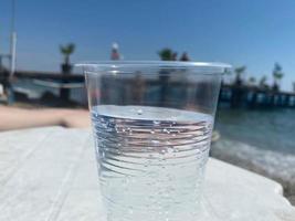 Cold water and soft drinks are poured in a glass and a bottle photo