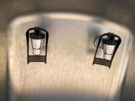 Metal shiny chrome faucets of a cooler with water and drinks, close-up view. Faucet for pouring drinks photo