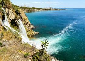 sea with blue water. waterfall in mountain gorge. a high mountain with stones, water flows down over the stones. waterfall with stream. sea cruise photo