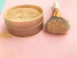 mineral powder in a pink round jar with a natural bristle brush. brush with white handle for applying makeup. creating perfect and beautiful beauty skin photo