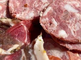 A plate with delicious red smoked meat, ham, bacon, lard, sausage and pork neck. The background. Texture photo