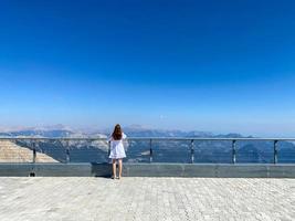 Woman at the observation deck in a deep canyon - breathtaking views of nature in the mountains photo