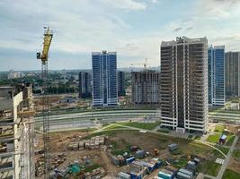 A view from a height of a large modern construction site of tall large houses and multi-storey buildings. A construction site for the development of a new microdistrict in a big city photo