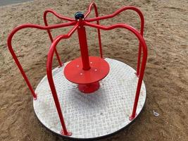 Children's round metal blue swing carousel for sports games in the courtyard of a new building on a children's playground photo