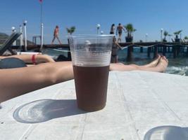 Cup of iced coffee with straw on table photo